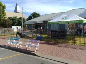 building with goolwa community centre branded marquee out the front and colourful painted benches