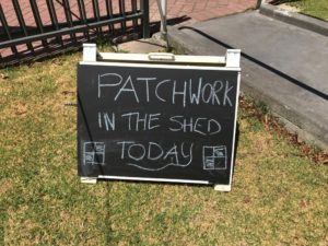 blackboard a-frame reads patchwork in the shed today